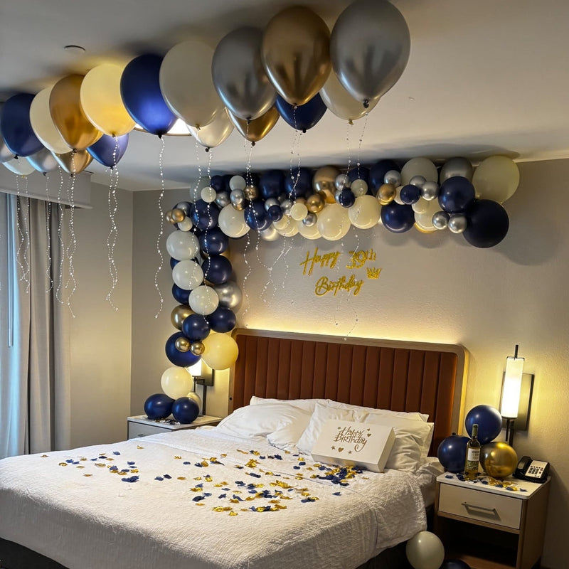 Decorated bedroom with balloons and 'Happy 39th Birthday' sign above a bed.
